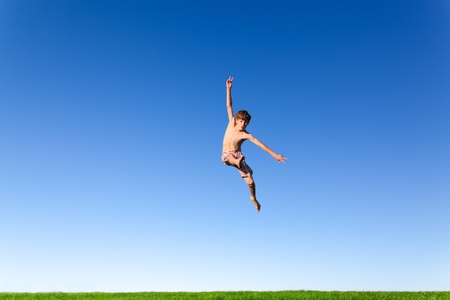 Happy young boy jumping in the meadow の写真素材