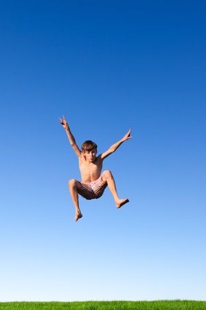 Happy young boy jumping in the meadow の写真素材
