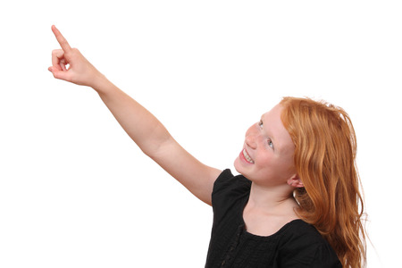 Happy young girl points up on white backgroundの写真素材