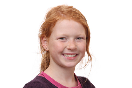 Portrait of a self confident red haired girl on white backgroundの写真素材