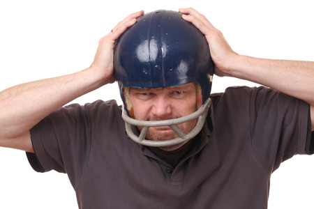 Portrait on an angry man wearing a football helmet on white backgroundの写真素材