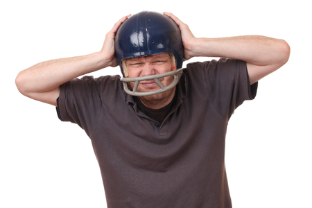 Portrait on an angry man wearing a football helmet on white backgroundの写真素材