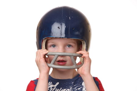 Portrait of a young boy with a football helmet on white backgroundの写真素材