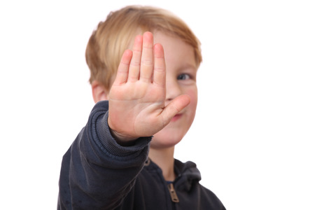 Portrait of a young boy holding out hand, indicating stopの写真素材