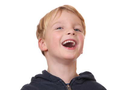 Portrait of a laughing young boy on white backgroundの写真素材