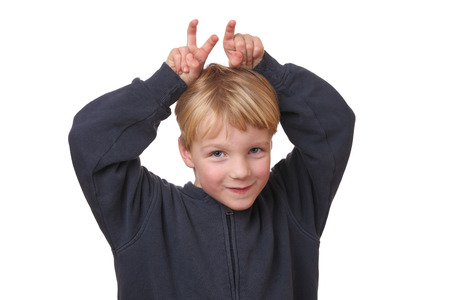 Portrait of a funny young boy with hands on his head on white backgroundの写真素材