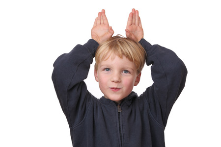 Portrait of a funny young boy with hands on his head on white backgroundの写真素材