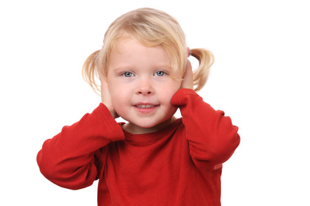 Portrait of a little girl covering her ears on white backgroundの写真素材
