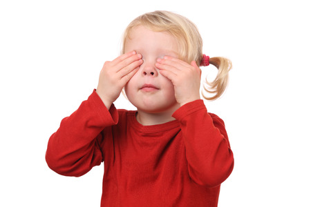 Portrait of a young girl covering her eyes on white backgroundの写真素材