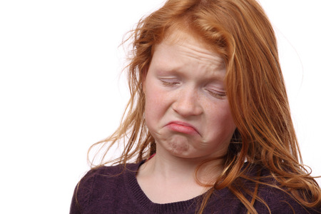 Portrait of a skeptical young girl on white backgroundの写真素材