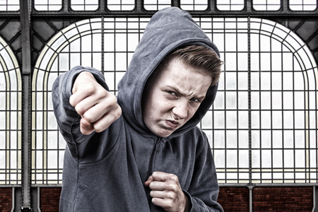 Angry young boy throws a punchの写真素材