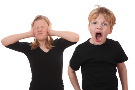 Screaming young boy and girl covering her earsの写真素材