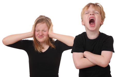 Screaming young boy and girl covering her earsの写真素材