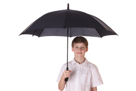 Portrait of a young boy with opened umbrella on white backgroundの写真素材