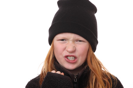 Portrait of an angry young girl on white backgoundの写真素材