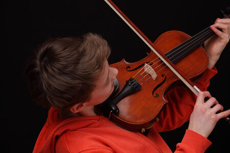 Young boy plays violin on blackの写真素材