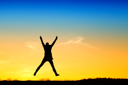 Active girl jump in meadow at sunsetの写真素材
