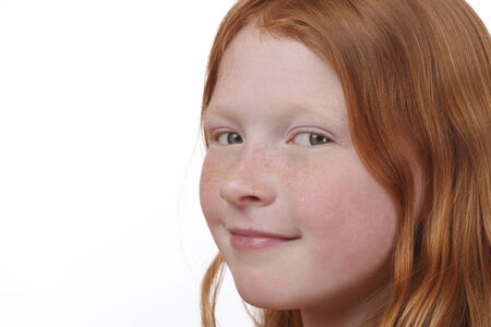 Young red-haired girl with freckles on white backgroundの写真素材