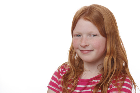 Young red-haired girl with freckles on white backgroundの写真素材