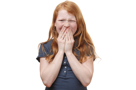 Portrait of a surprised young girl covering her mouth with handsの写真素材
