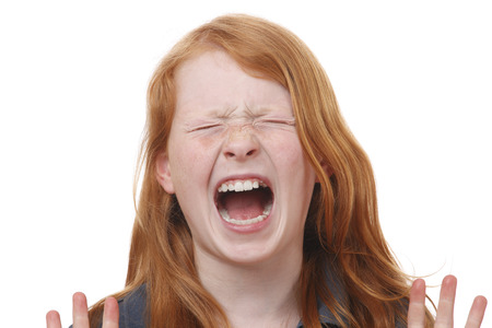 Portrait of a screaming young girl on white backgroundの写真素材