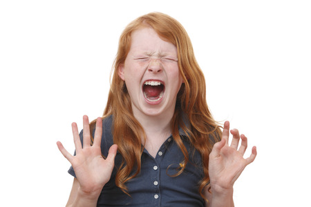 Portrait of a screaming young girl on white backgroundの写真素材