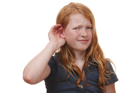 Portrait of a listening young girl on white backgroundの写真素材
