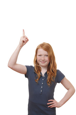 Portrait of a young girl pointing up on white backgroundの写真素材