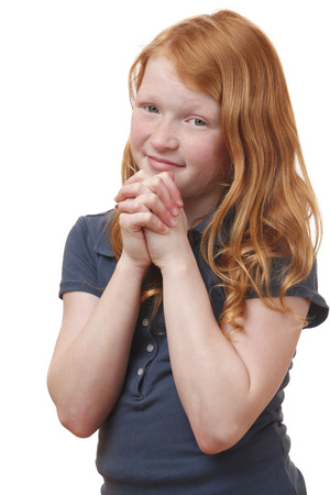 Portrait of a praying young girl on white backgroundの写真素材