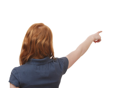 Portrait of a young girl pointing up on white backgroundの写真素材