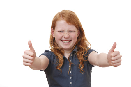 Portrait of a young girl showing thumbs up on white backgroundの写真素材