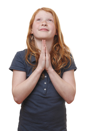Portrait of a praying young girl on white backgroundの写真素材