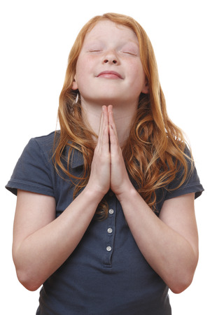 Portrait of a praying young girl on white backgroundの写真素材