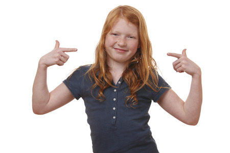 Portrait of a young girl pointing up on white backgroundの写真素材