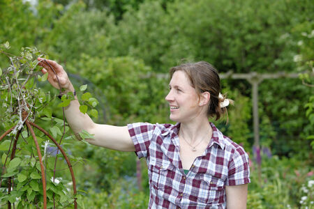 Young woman working outdoors in the gardenの写真素材