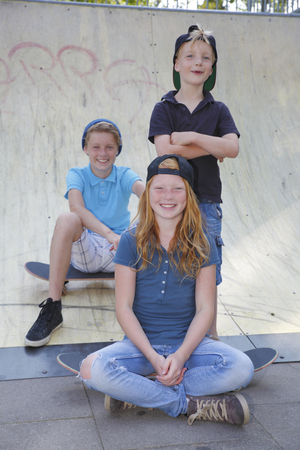 Cool young boys and girl outdoor with skateboardの写真素材
