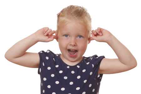 Stressed young girl covers ears with hands on white backgroundの写真素材
