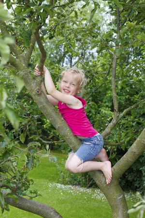 Happy young girl plays in the gardenの写真素材