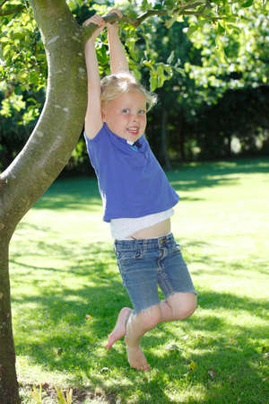 Happy young girl plays in the gardenの写真素材