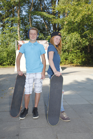 Cool young boy and girl outdoor with skateboardの写真素材