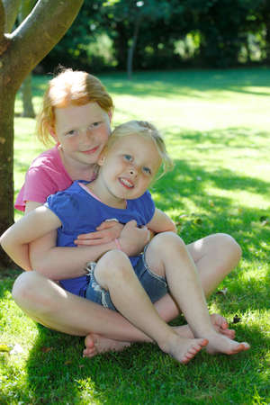 Two happy young girls in the gardenの写真素材