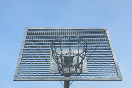 Metal basketball hoop in front of blue skyの写真素材