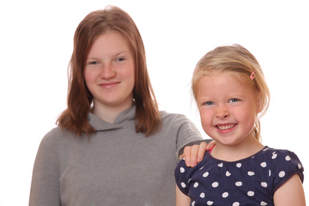Portrait of two happy young children on white backgroundの写真素材