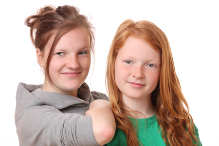 Portrait of two happy teenage girls on white backgroundの写真素材