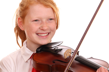 Portrait of a young girl playing violin on white backgroundの写真素材