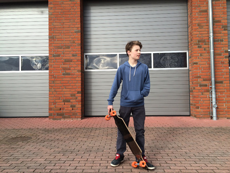 Relaxed young boy with longboardの写真素材