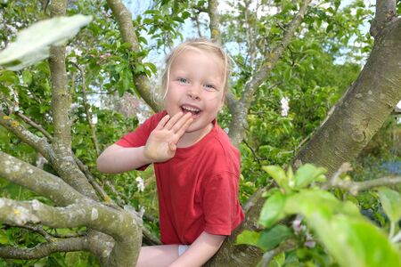 Happy young girl climbing in a treの写真素材