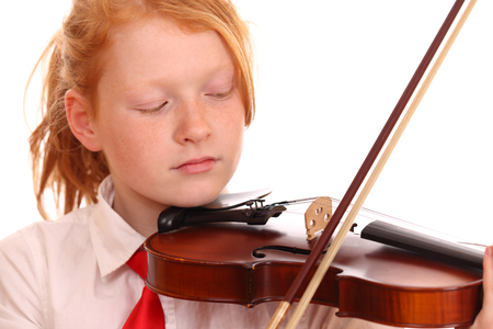 Portrait of a young girl playing violin on white backgroundの写真素材