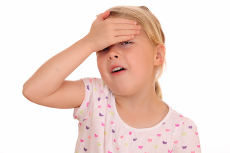 Portrait of a young girl covering her eyes on white backgroundの写真素材