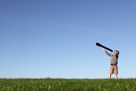 Young boy with telescope watching the skyの写真素材